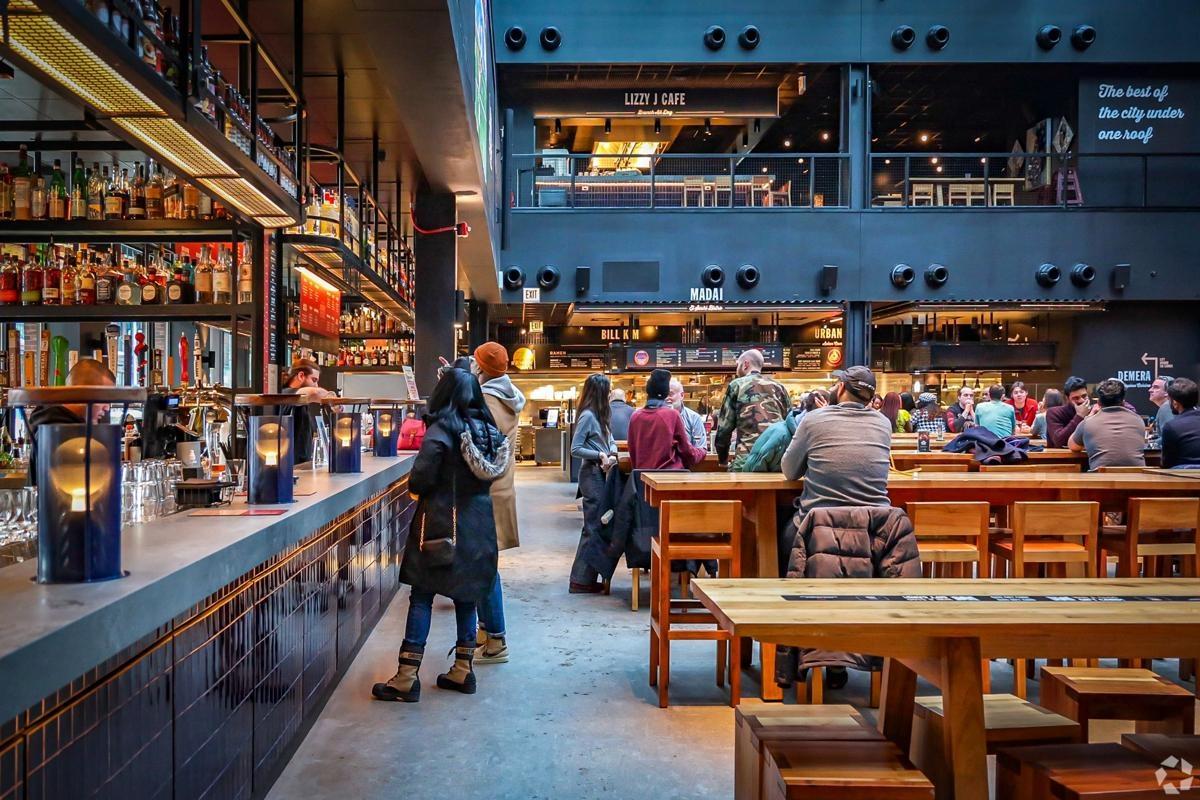 Interior of Time Out Market with bustling food vendors and diners, showcasing Chicago’s best eats under one roof near downtown rentals.