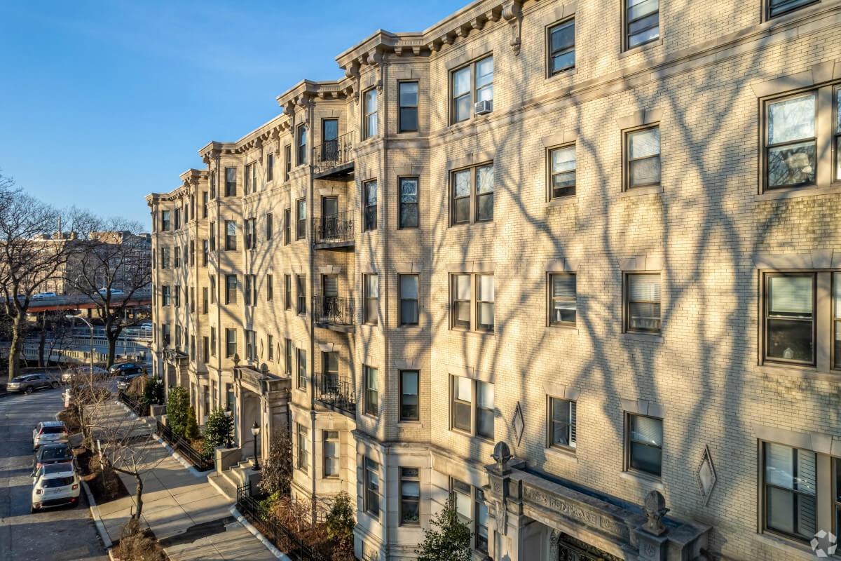 A view of graystone buildings along a sidewalk in Boston.