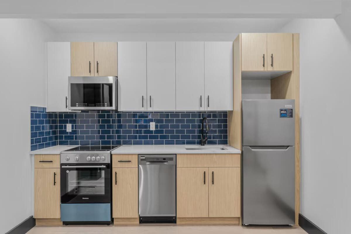 A view of kitchen at 2486 Hughes Ave shows blue backsplash and stainless-steel appliances.