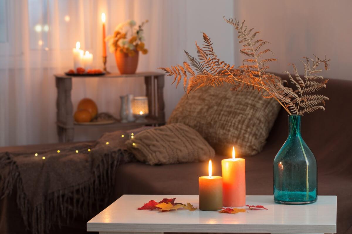 Fall candles and autumnal florals in an apartment living room set a relaxed mood.