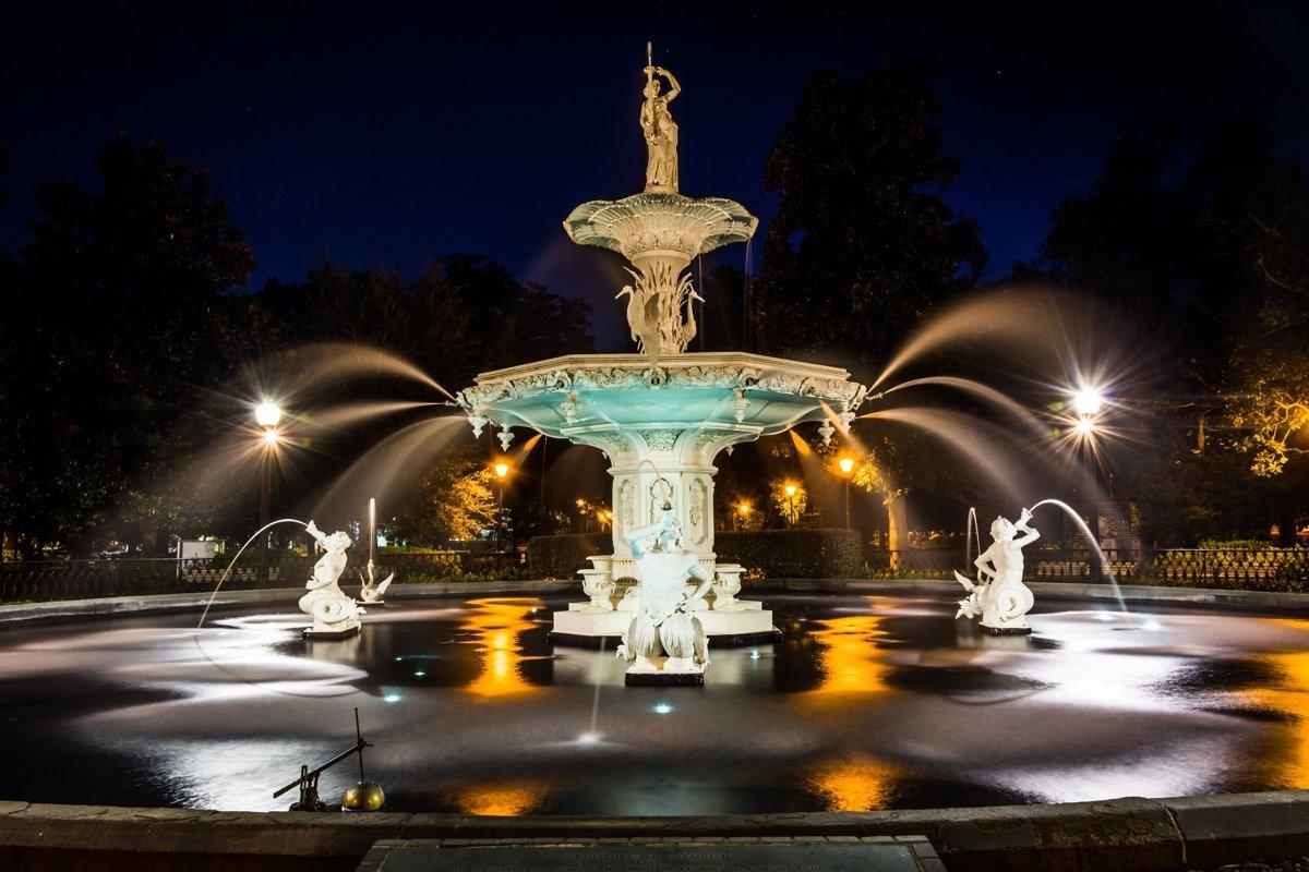 Large water fountain at night in a lighted display
