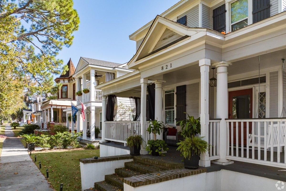 A row of two-story houses on a tree-lined street