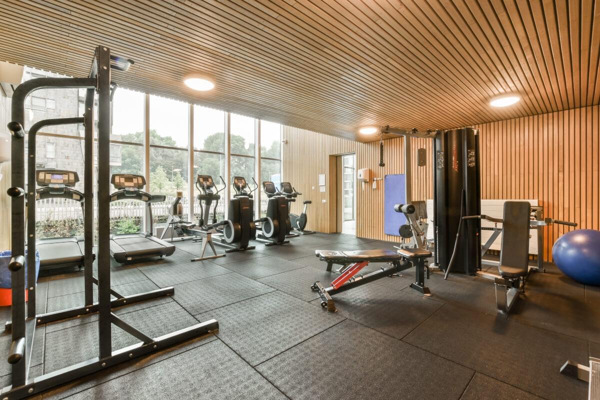 An apartment fitness center equipped with cardio machines, free weights, and resistance training machines.