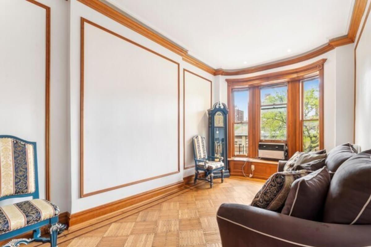 The living room at 44 West 91st Street in Manhattan has parquet flooring and a bay window.