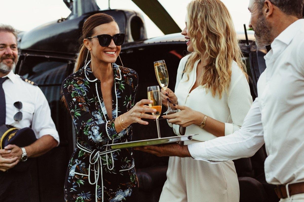 Millionaires toasting champagne in front of a private jet