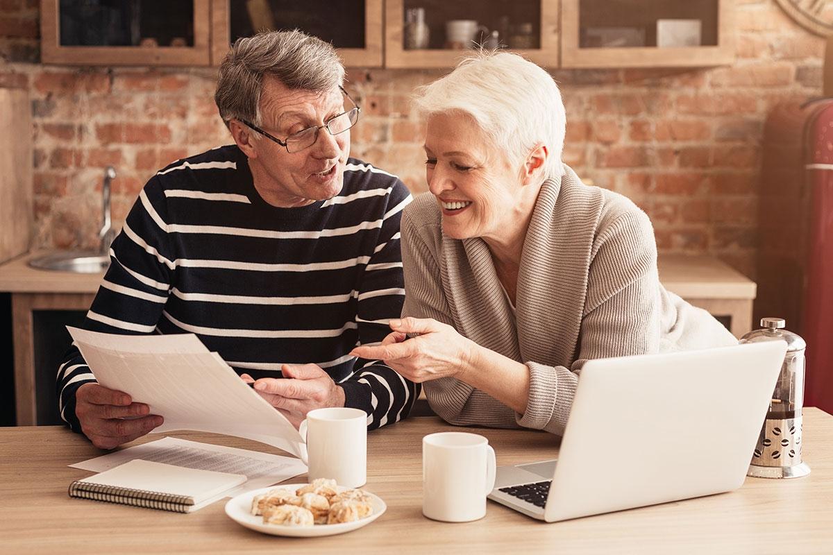Senior couple happily working together to apply to senior housing.