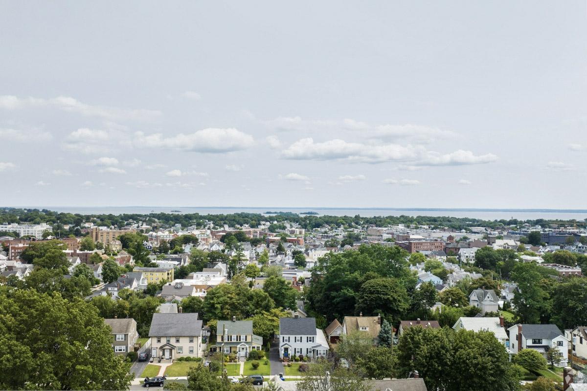 An aerial view of quaint houses in Port Chester with the Hudson River in the distance.