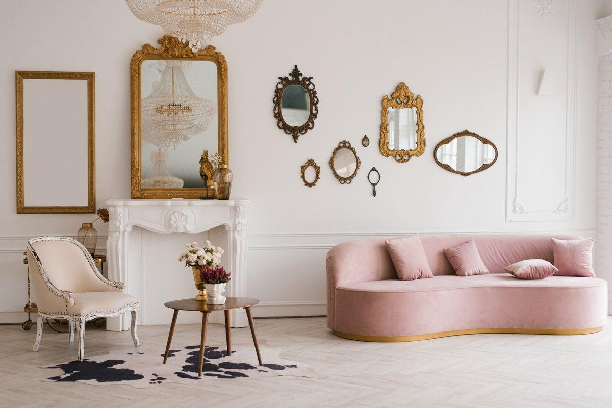 Wall of mirrors of various shapes and sizes hanging over a sofa