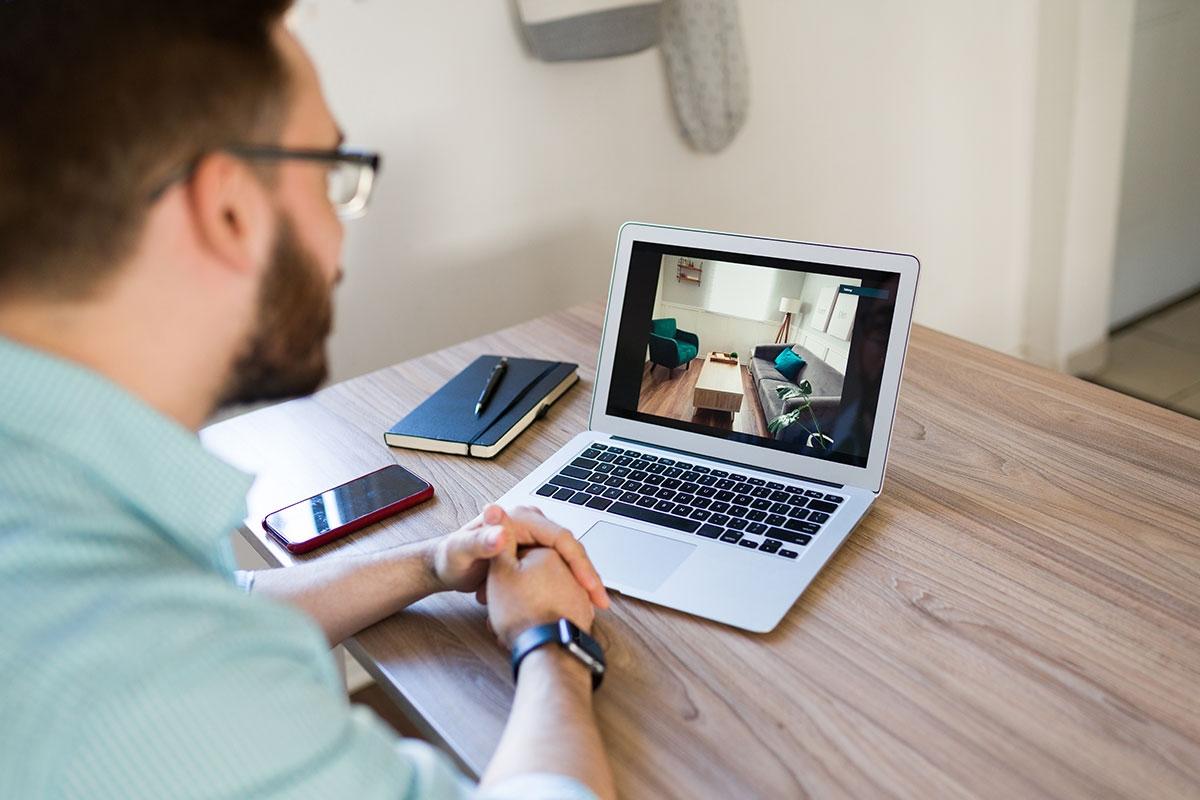 Man taking a virtual tour of an apartment on his laptop.