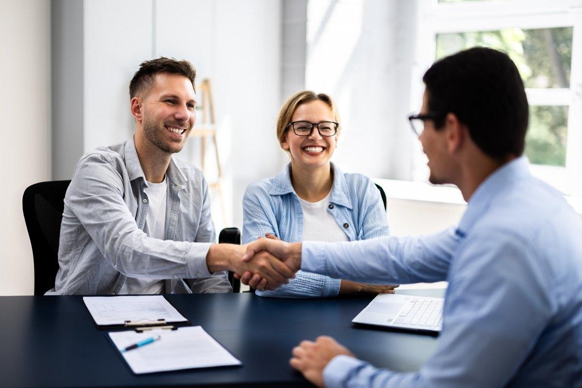 A couple shaking hands with the landlord