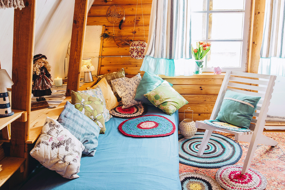 A cabin with a seating area that features many throw pillows of different colors and patterns. It has a mix of boho accents and traditionalist decor. 