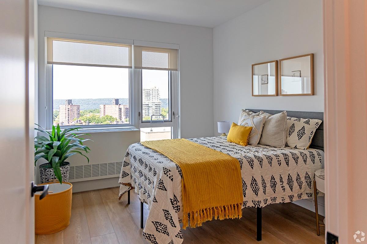 A modern bedroom has a wall a/c unit to keep it cool.