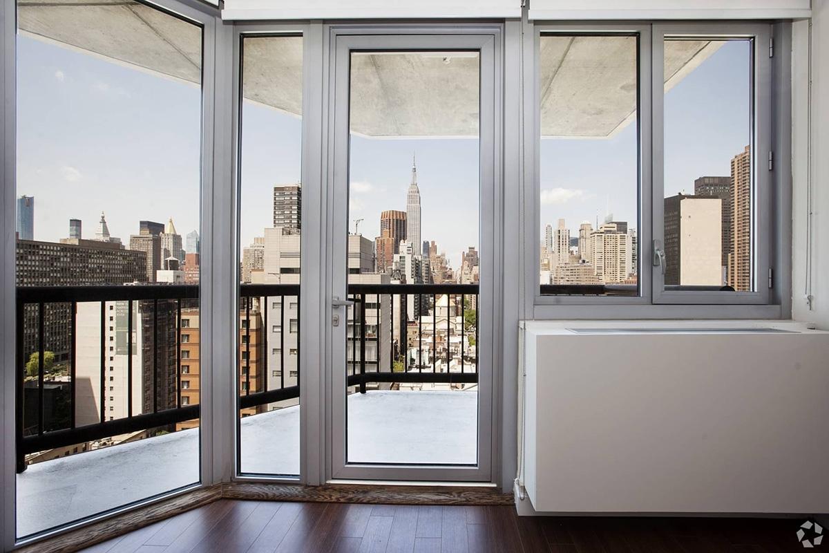 Glass doors of a high-rise apartment show a balcony.
