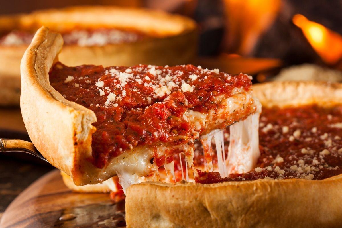A slice of deep dish pizza topped with parmesan cheese
