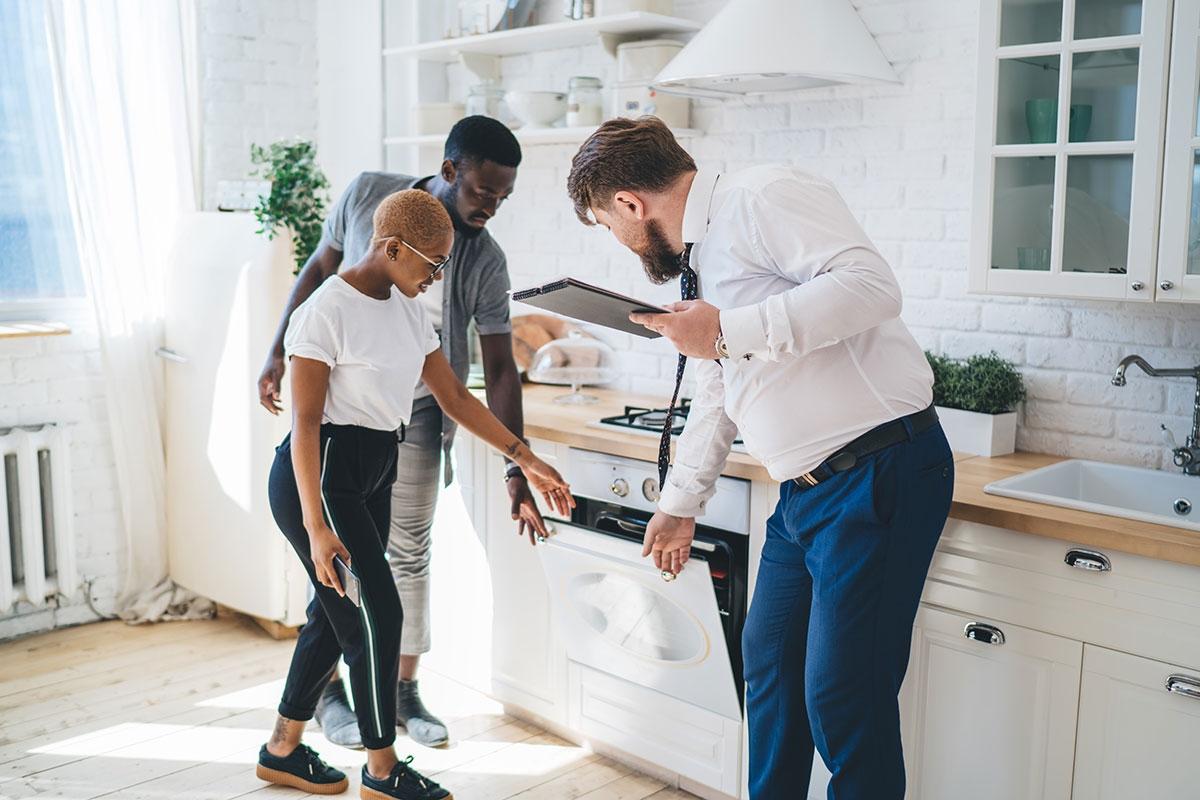 Renters inspecting appliances during an apartment tour.