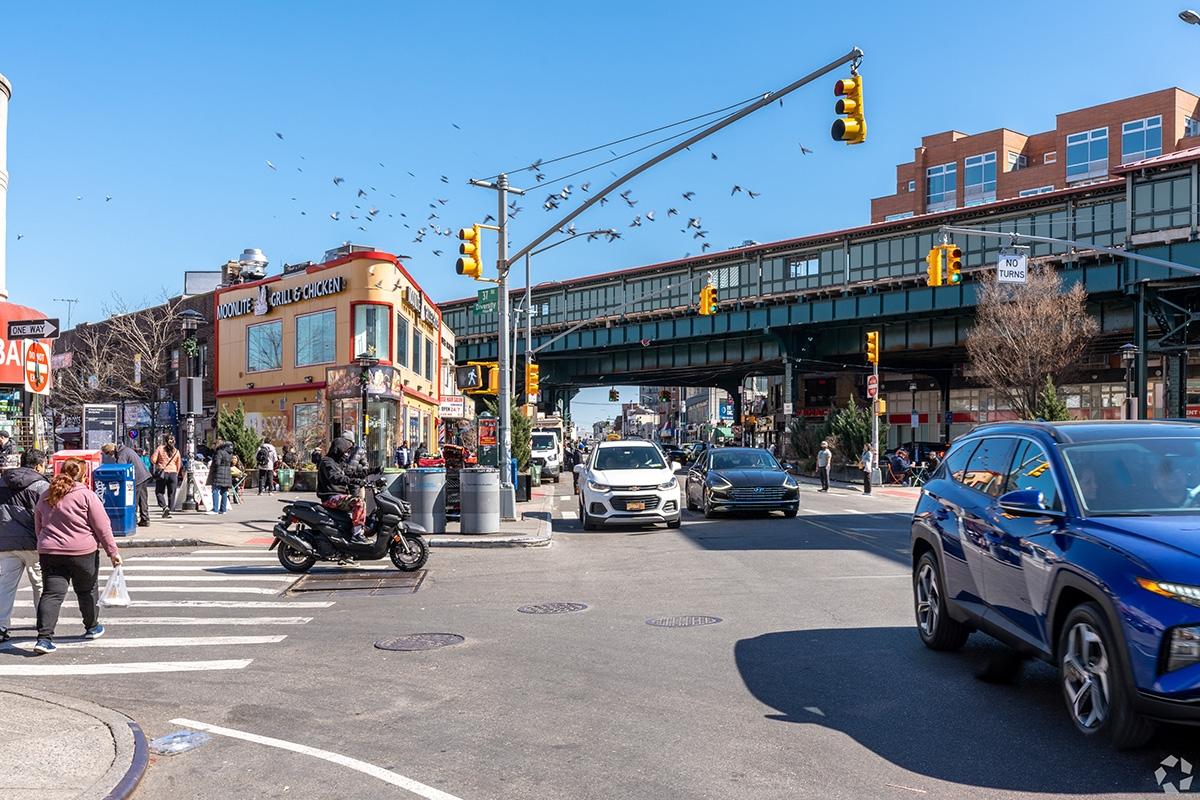 A busy intersection with pedestrian and cars in Jackson Heights.