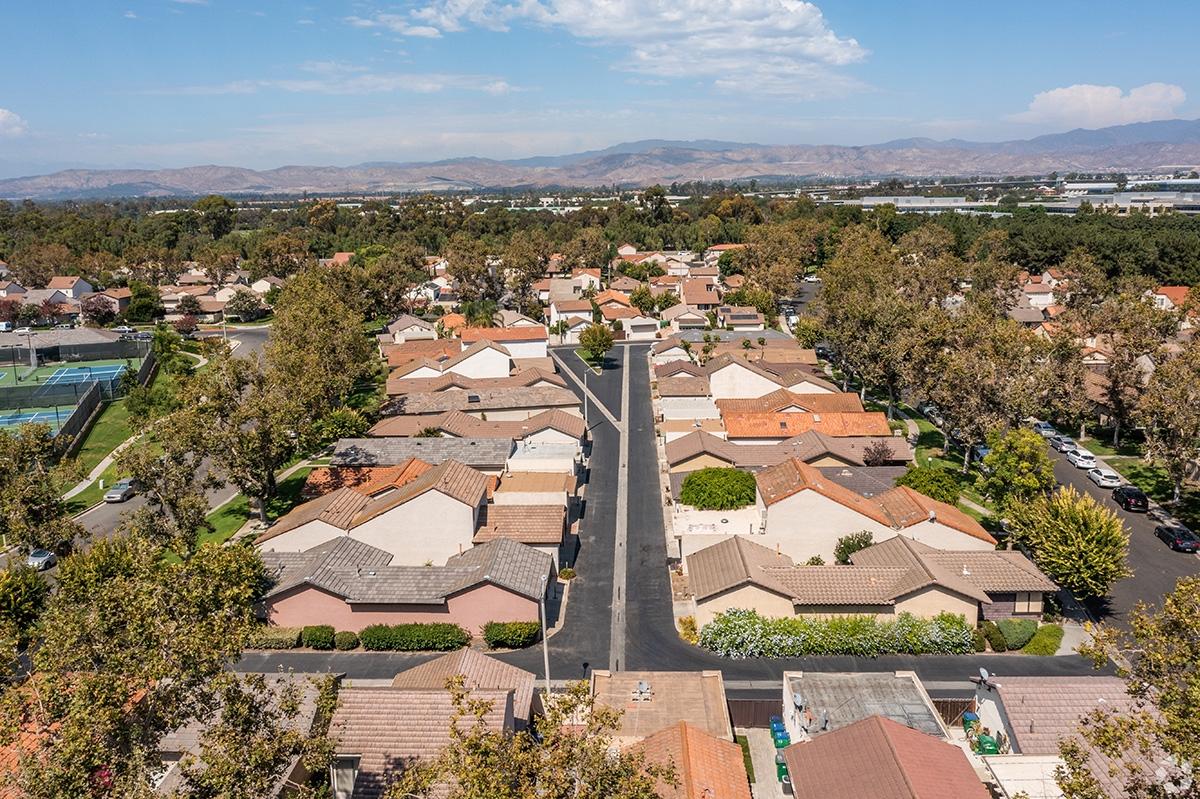 An aerial view of the Oak Creek neighborhood in Irvine shows apartment communities and a mountain range in the distance.