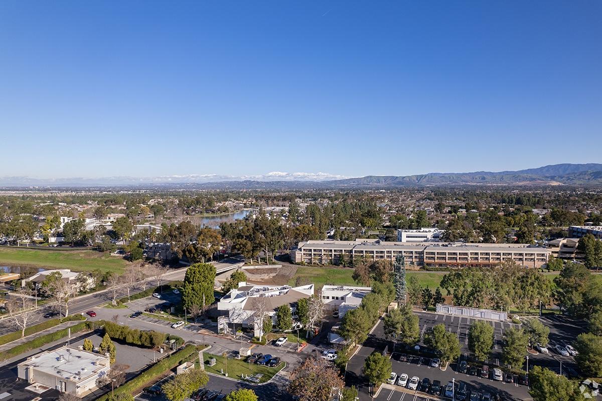 An aerial view of the Woodbridge neighborhood in Irvine with mountains in the background.