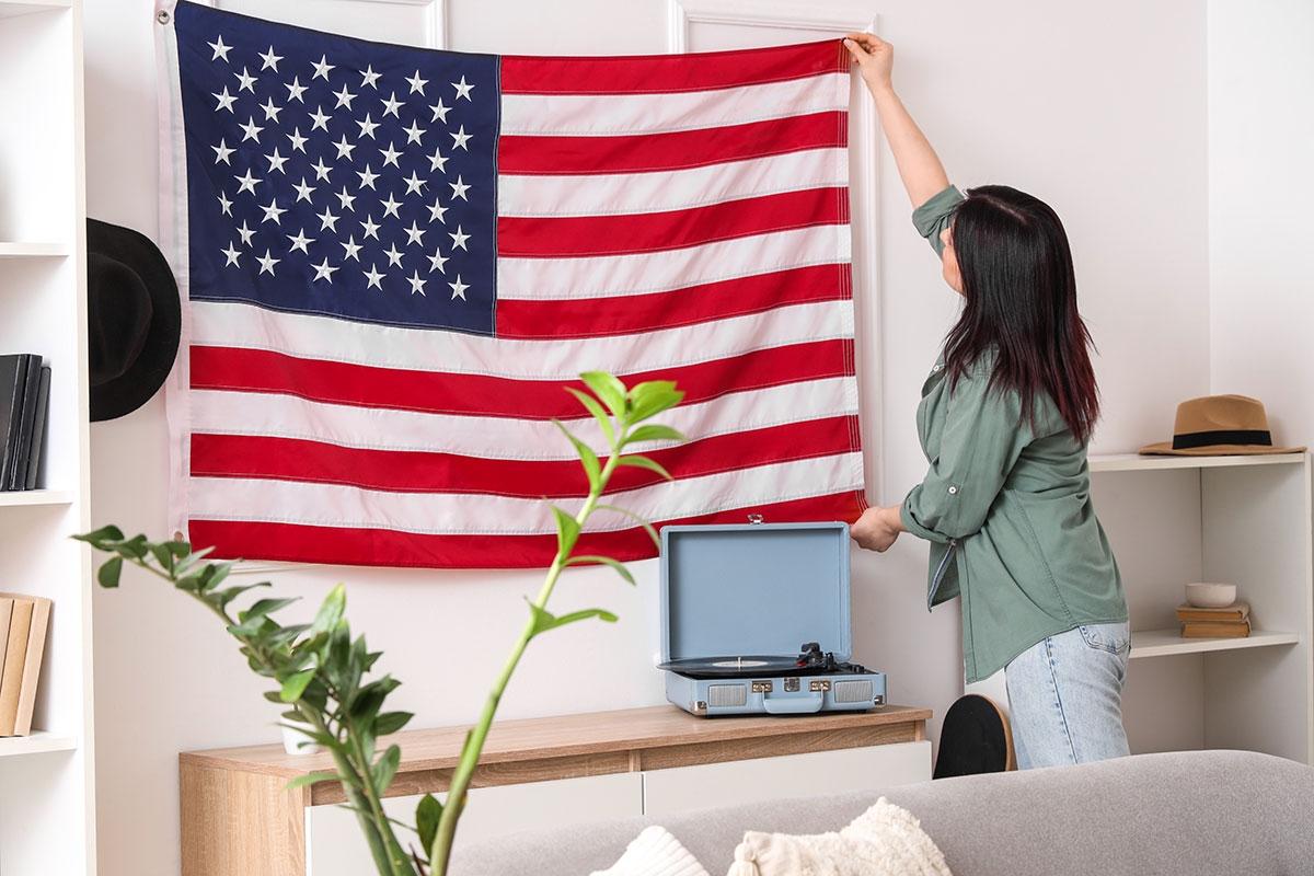 Women hanging the American flag in her apartment.