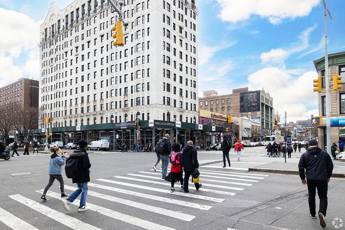 People cross a street in Central Harlem.
