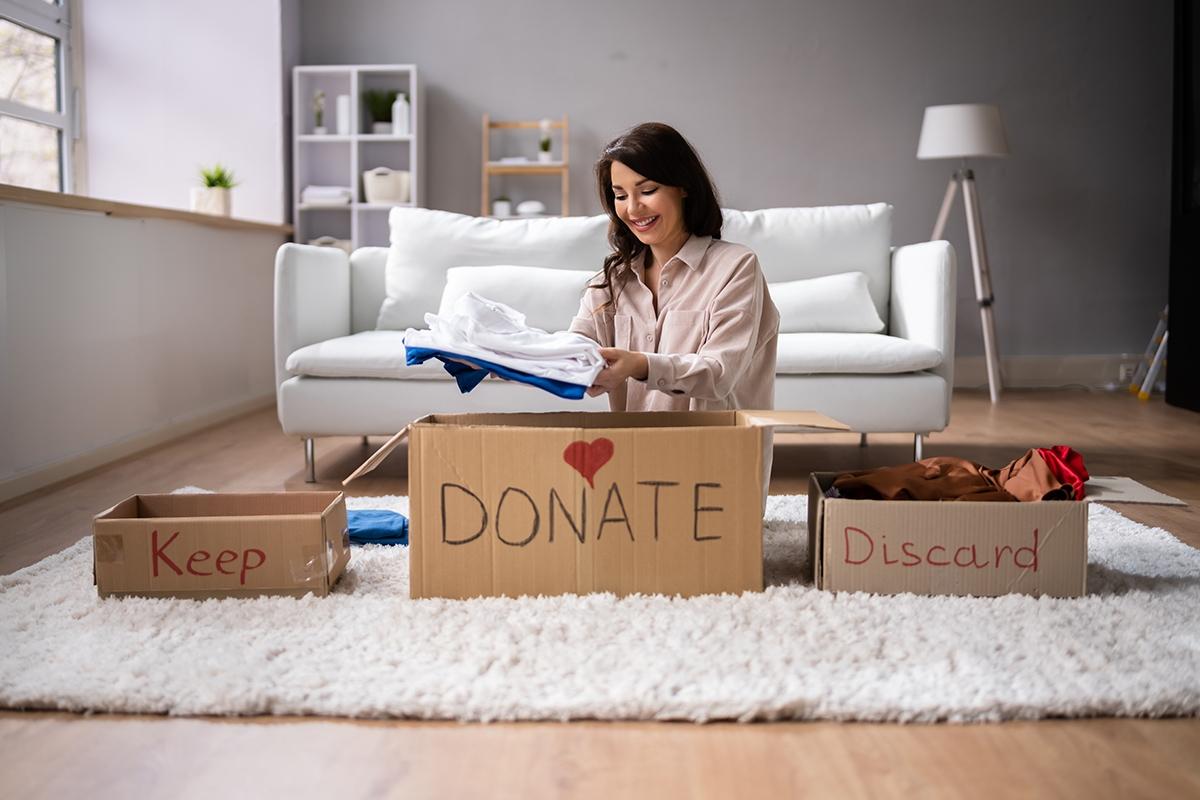 A woman sorting clothes using the four box method.