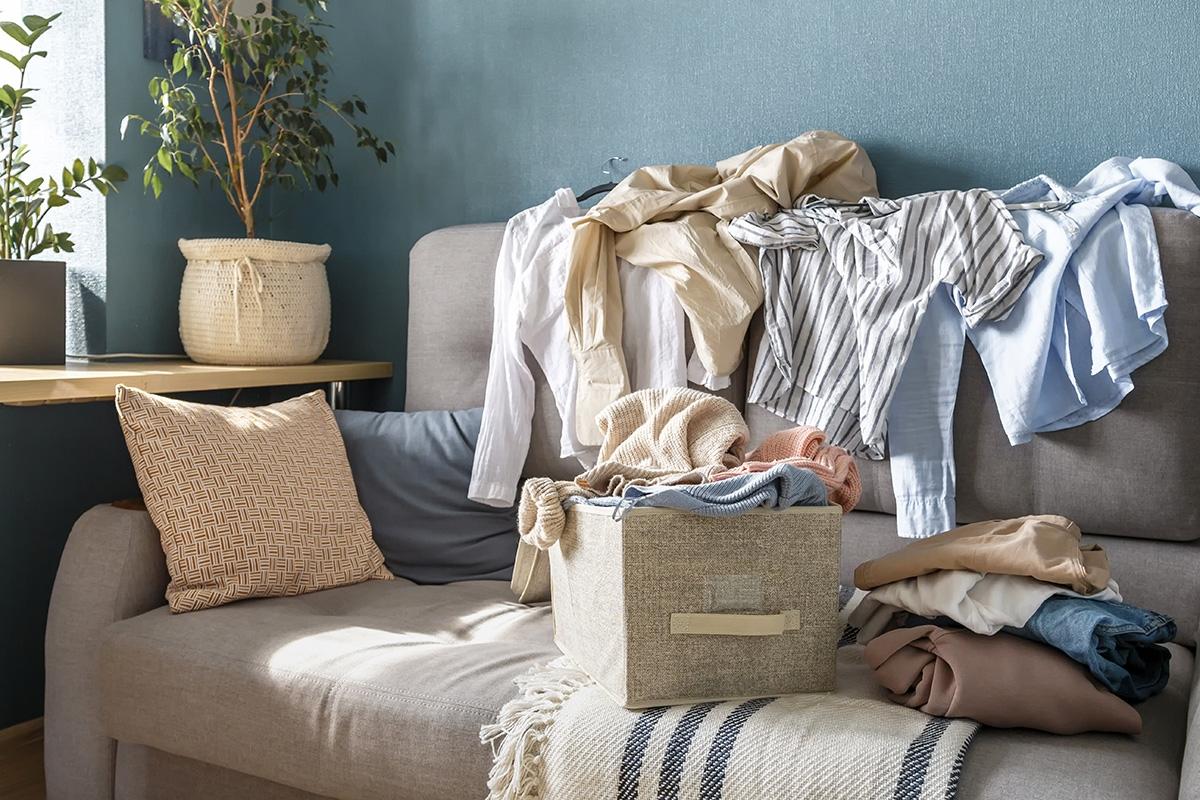 A pile of clothes and belongings on a couch.