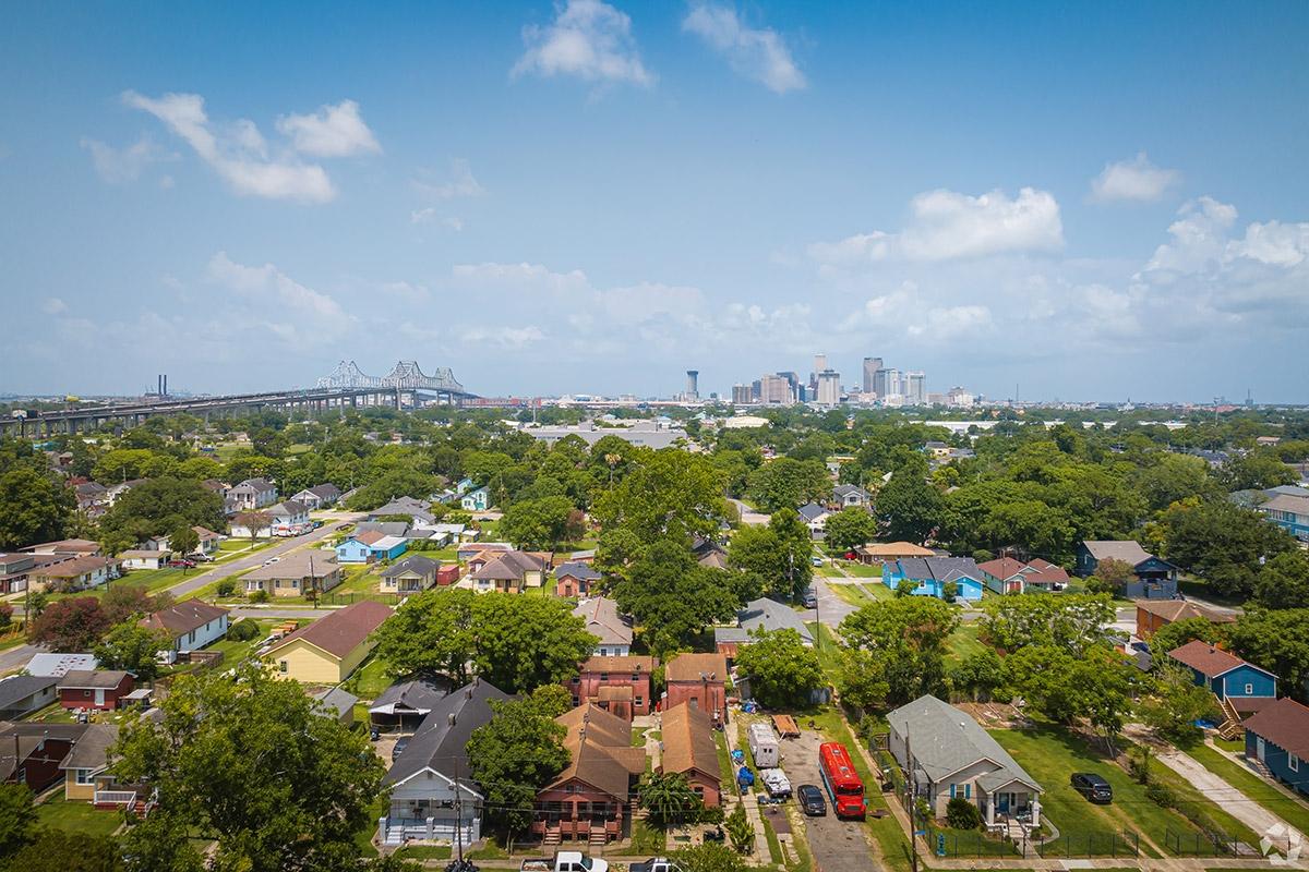 The Downtown New Orleans skyline rises in the distance behind Behrman as the neighborhood sits across the Mississippi River.