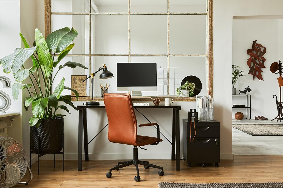 A beautifully designed desk with lots of plants and wood.