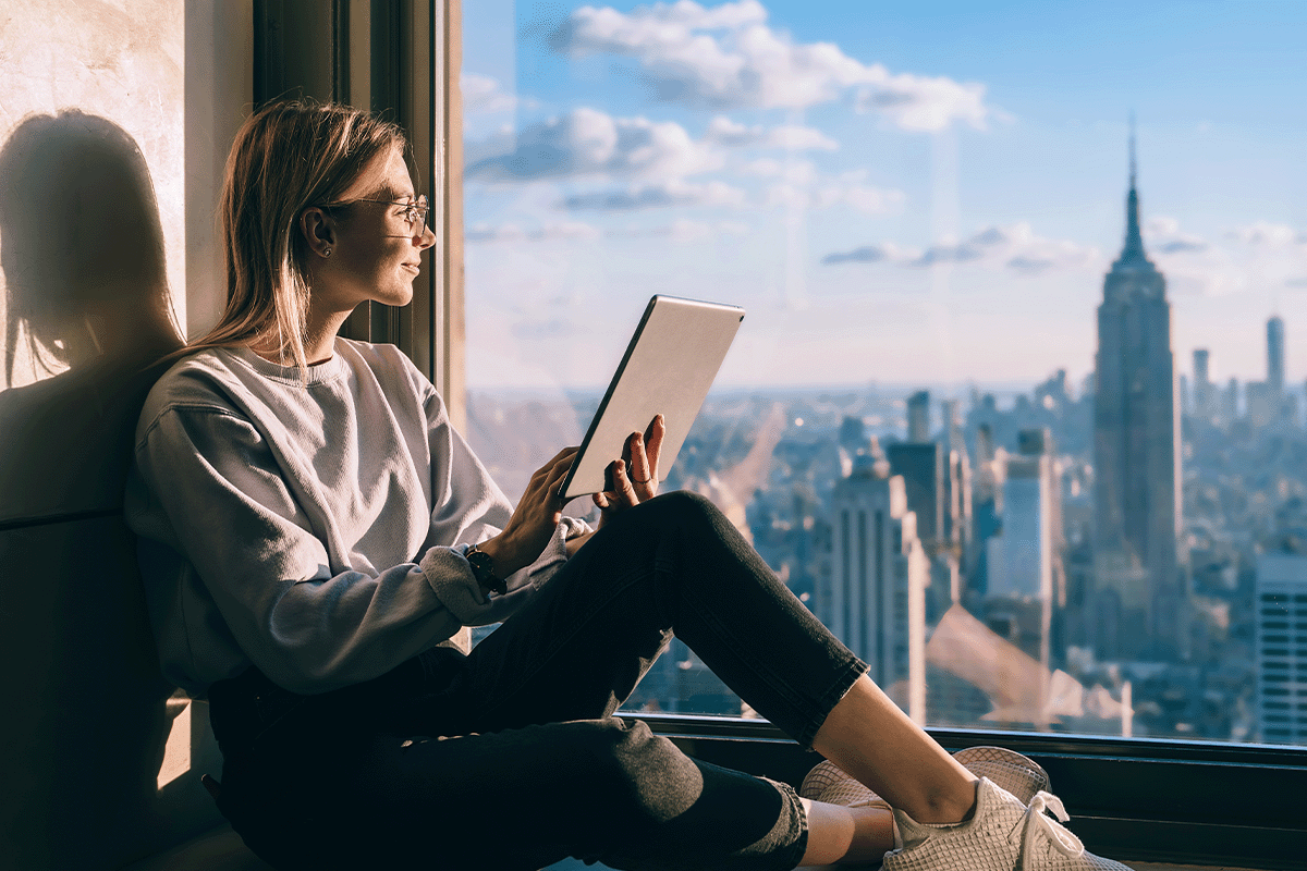 Woman looking at the Empire State Building from her studio apartment in New York City