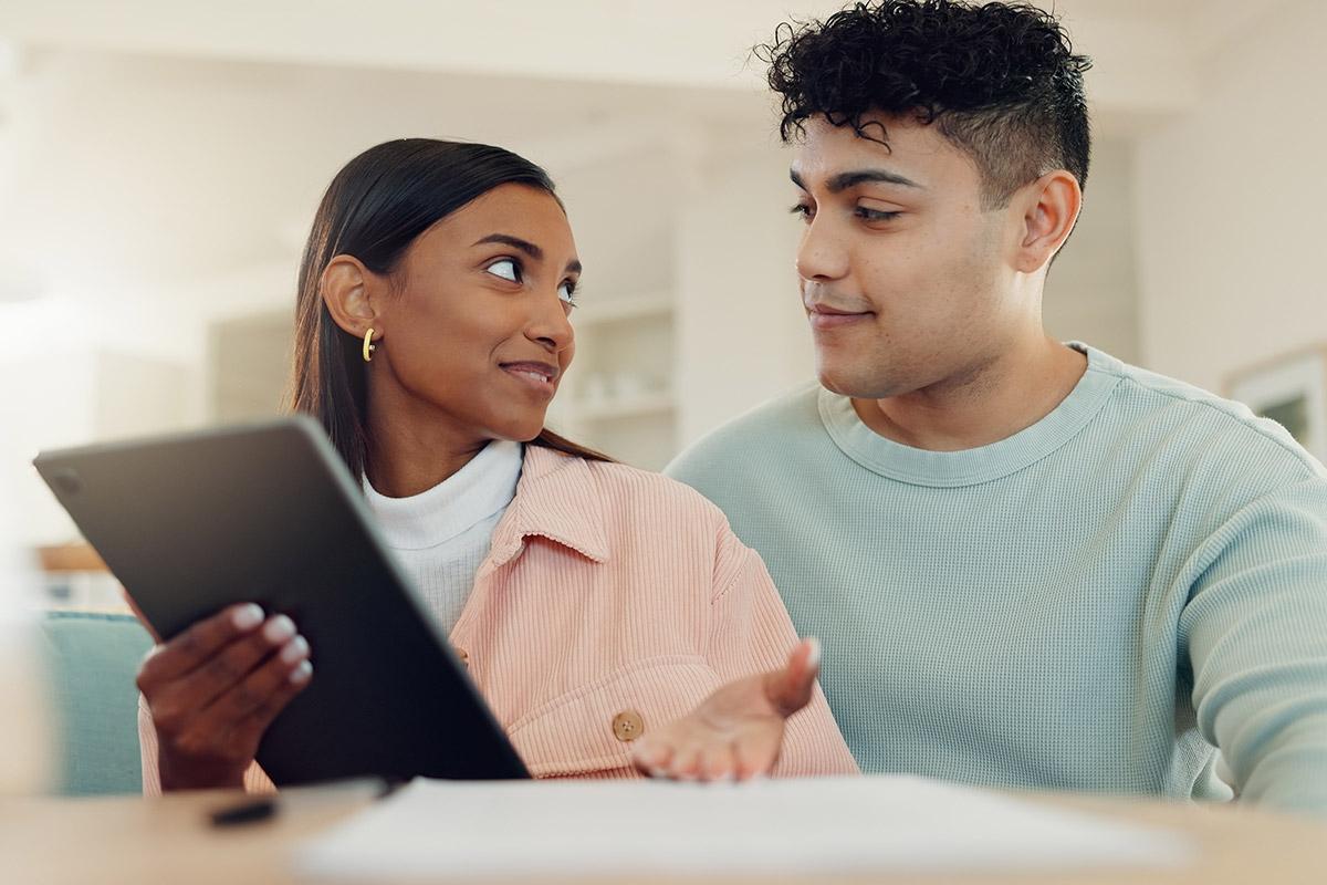 Man and woman looking at a table and discussing what is on it.