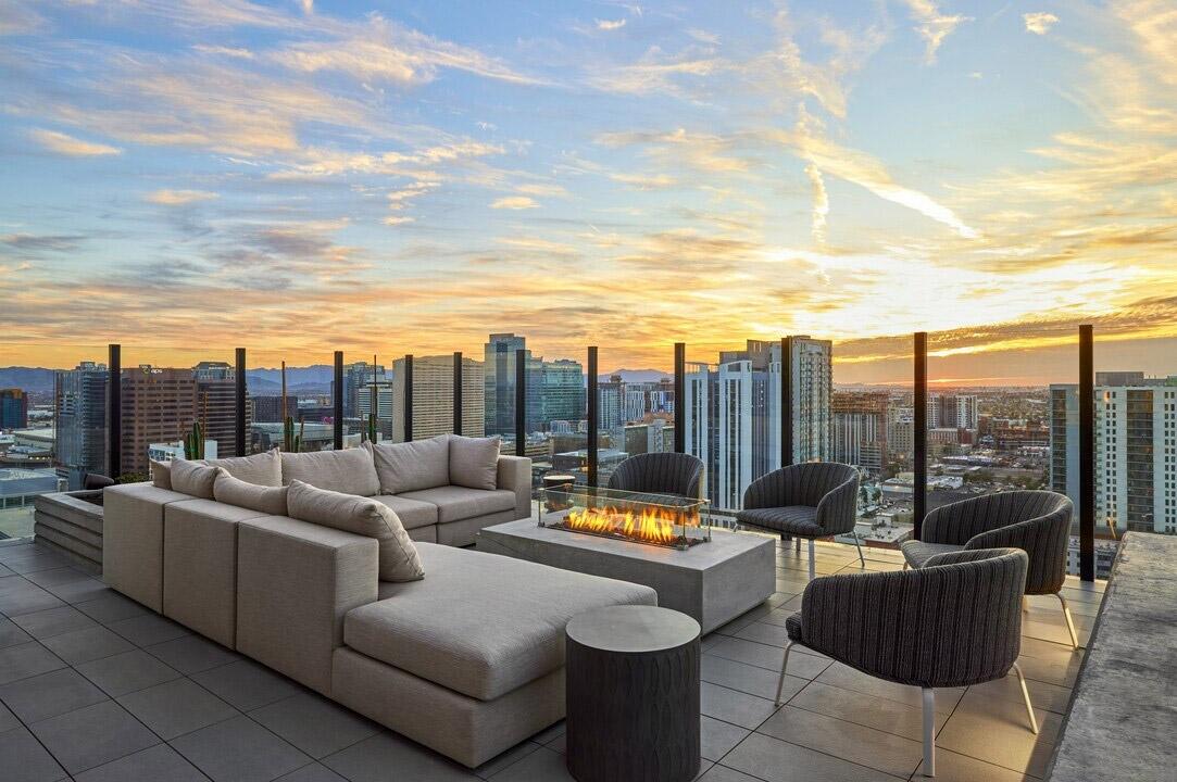 An outdoor lounge with a firepit overlooks the rest of Downtown Phoenix from a luxury apartment community.