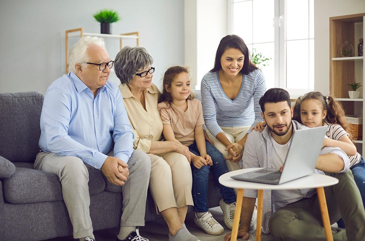 Multigenerational family looking at laptop.