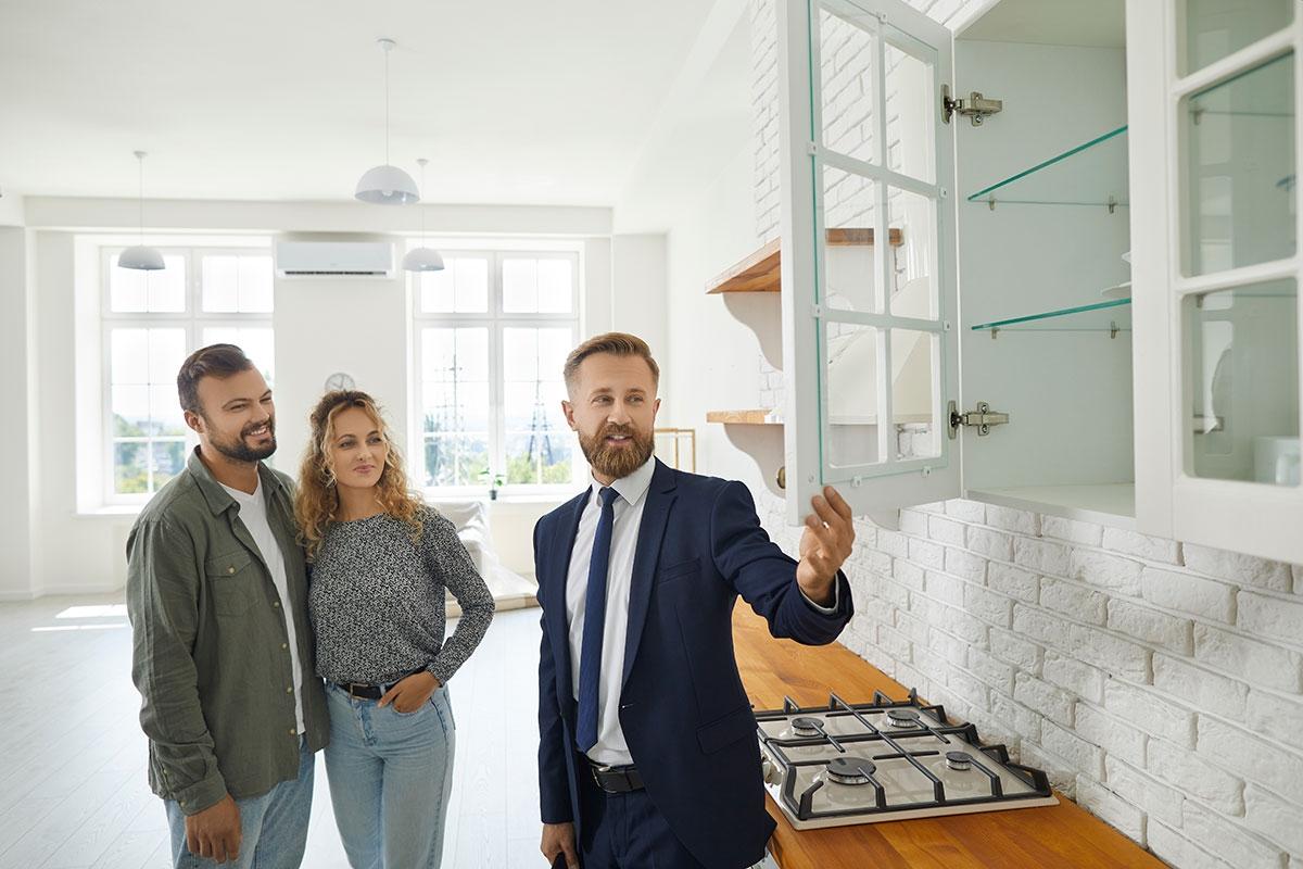 A renter couple touring an apartment with a leasing agent.