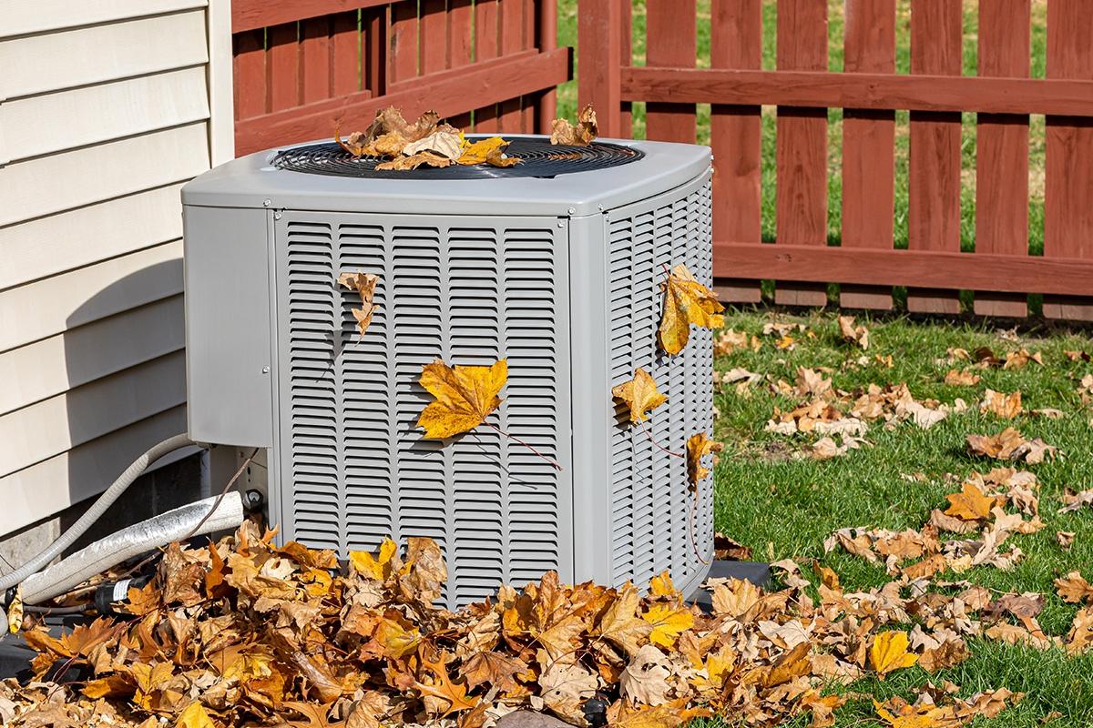AC unit covered in fall leaves