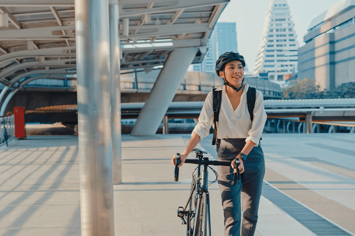 Woman walking next to her bike during her commute
