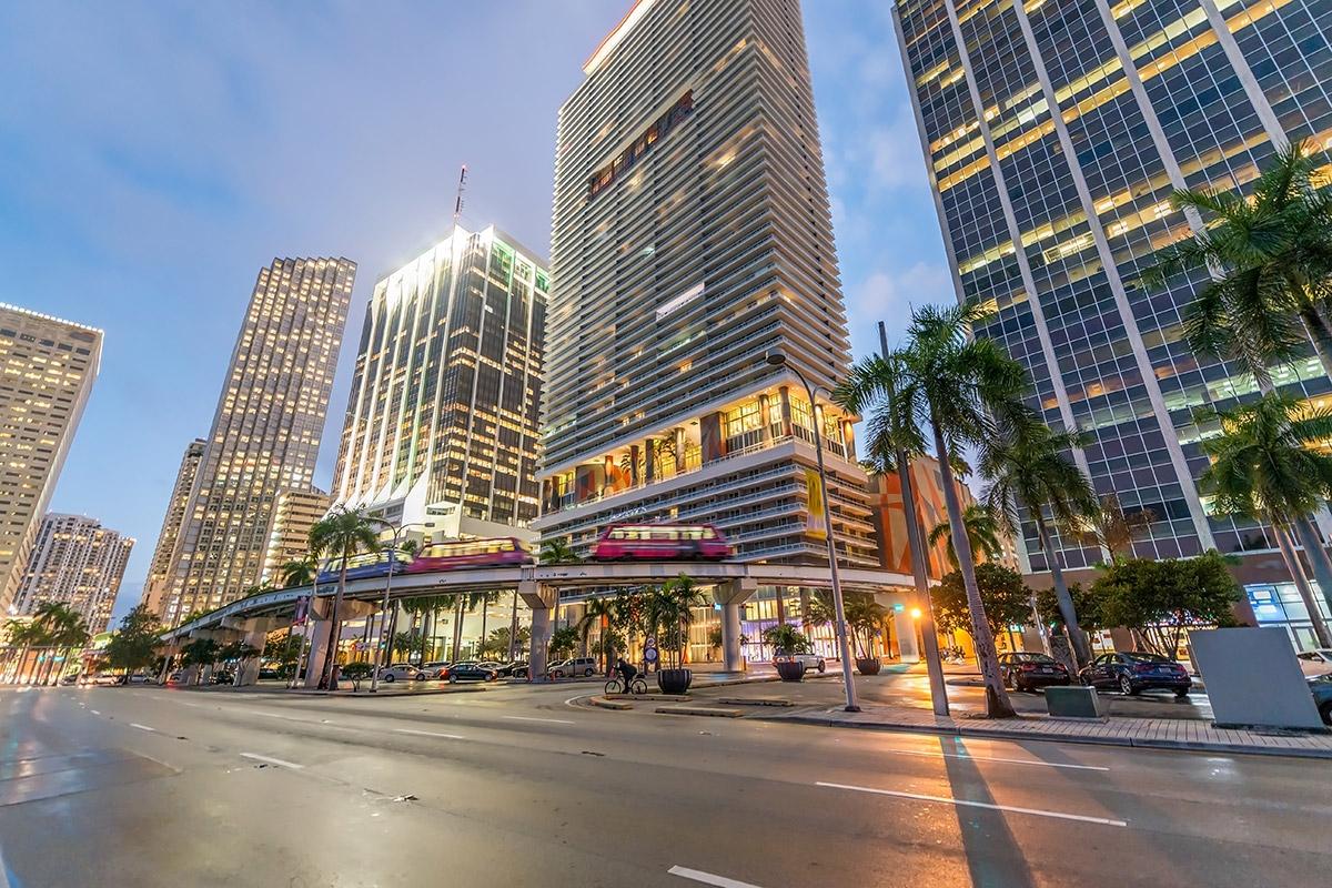 A downtown street with public transit running past high-rises.