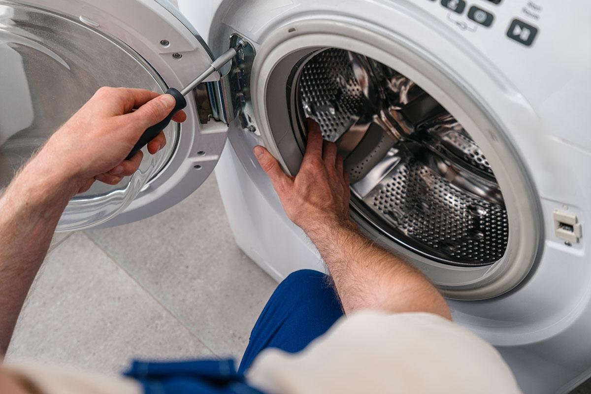 Someone installing a washer and dryer.