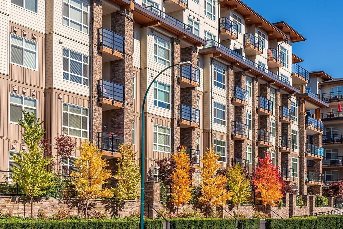 Photo of apartment building surrounded by fall foliage.
