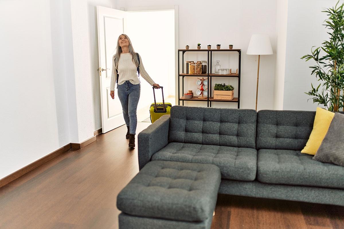 A renter coming back to her apartment with luggage after being away temporarily.