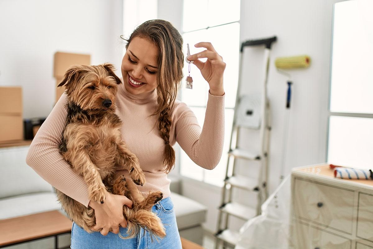 Girl in her new apartment with her pet dog. 