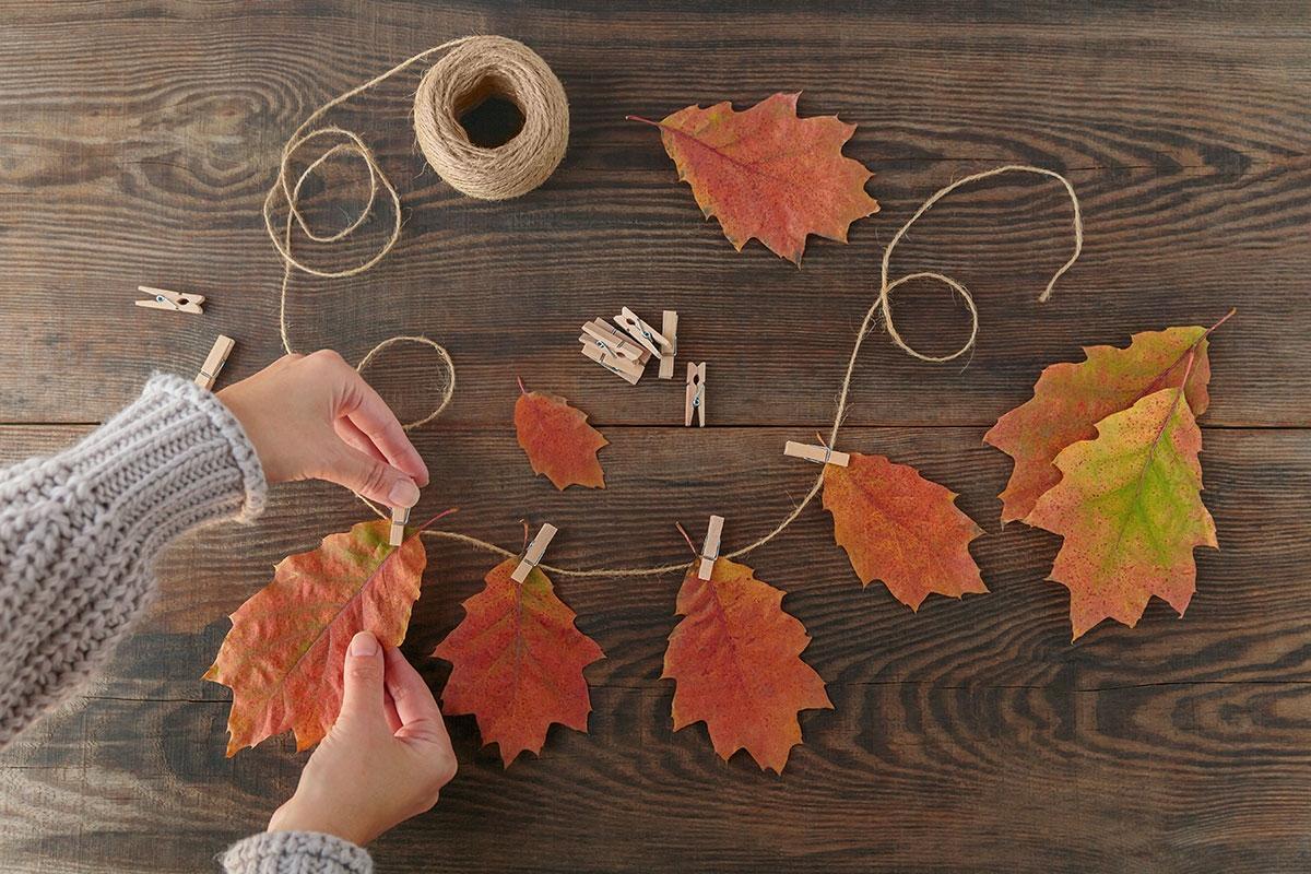 Renter creating a seasonal fall garland for apartment decor.