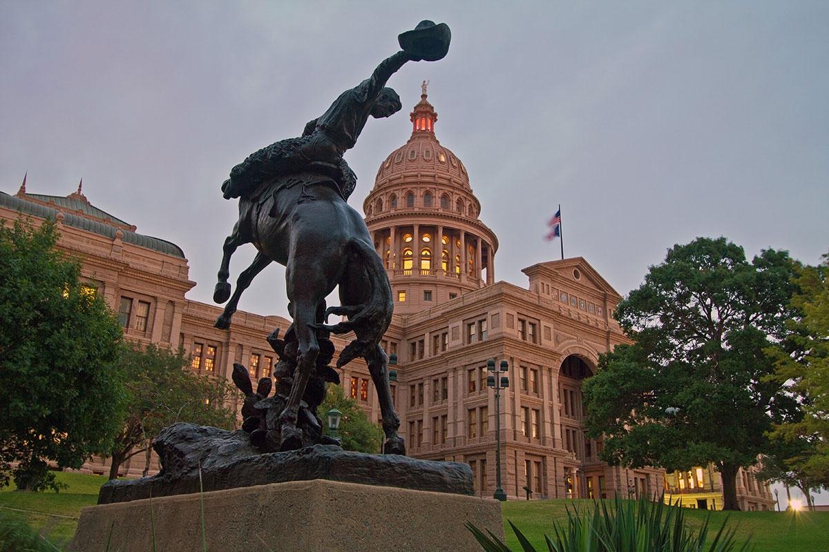 The capitol building in Austin, featuring the cowboy statue found on the outside.