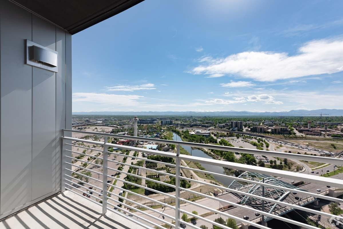 A balcony in a high-rise overlooks the river and roads in Denver.