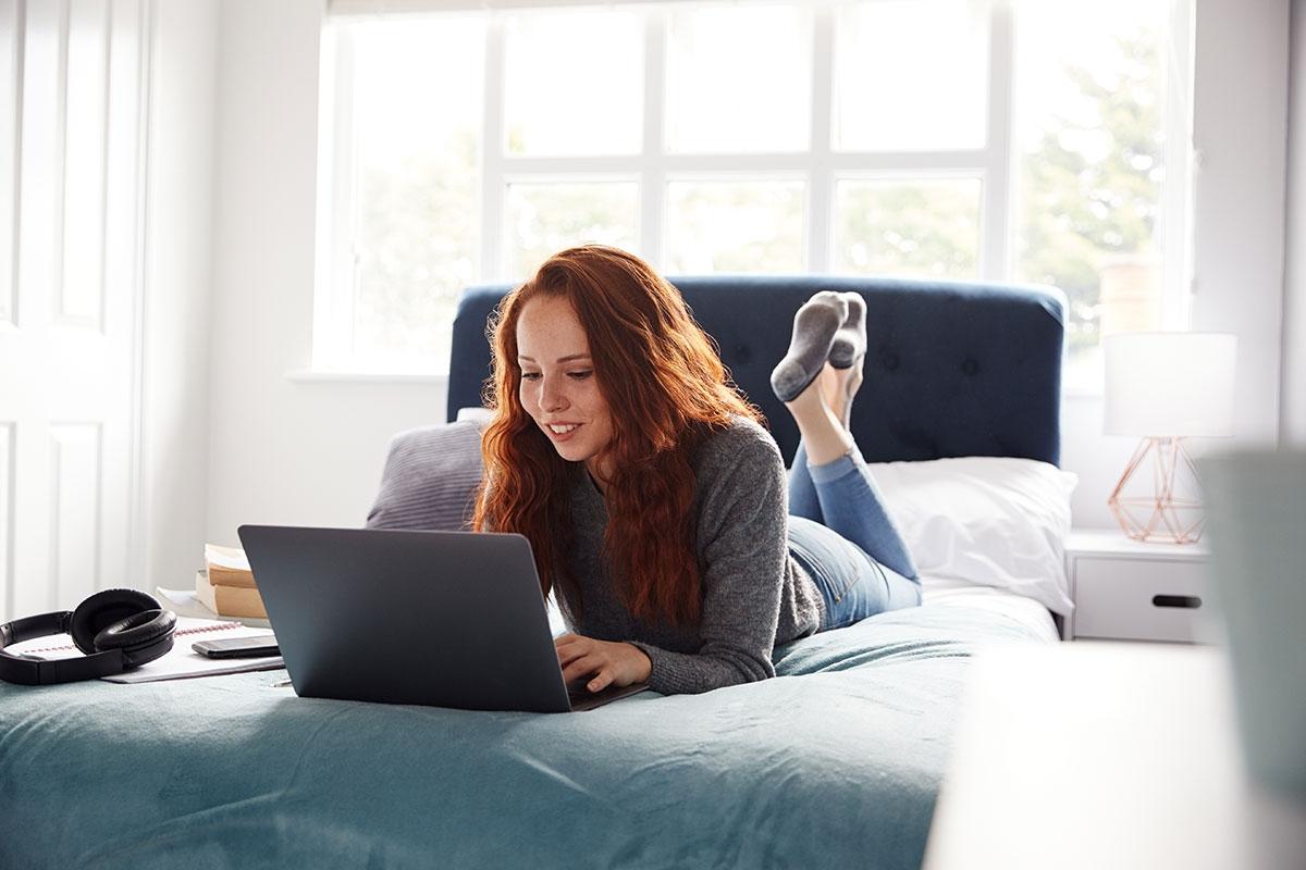 Student renter searching for an off-campus apartment on her laptop.
