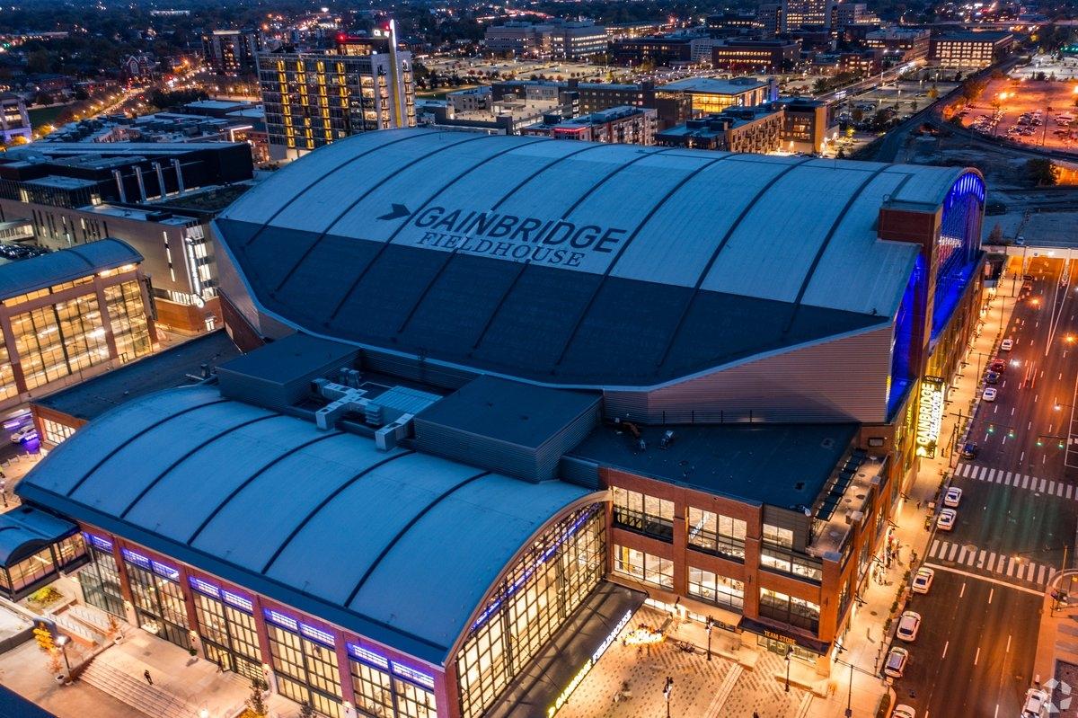 Gainbridge Fieldhouse lights up at night, along with the surrounding city blocks.
