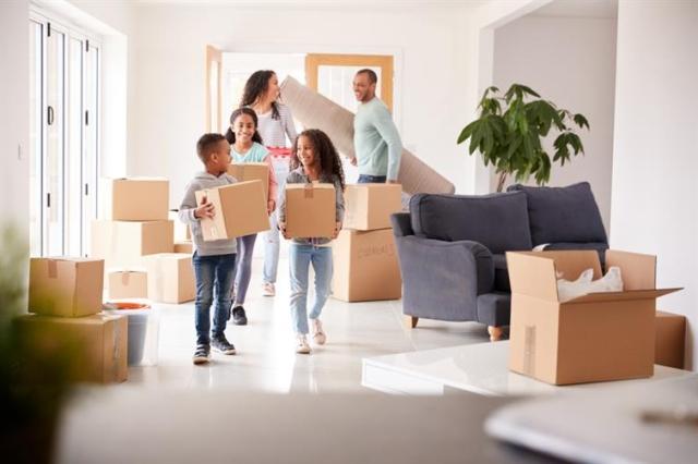 A family moves packing boxes out of an apartment.