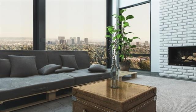 A plant sitting on a coffee table in a living room of a high-rise apartment unit
