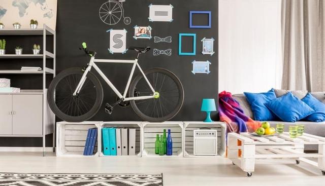 A small, well organized space. A bike leans against a wall covered in picture frames.