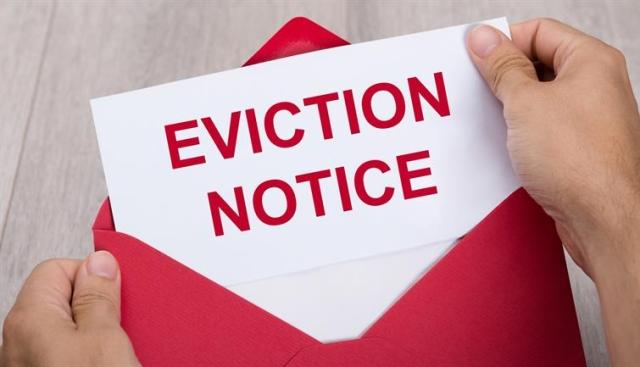 Hands opening an envelope, revealing letter reading "eviction notice"