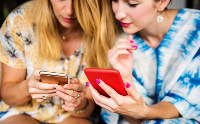 Two women looking at their phones together